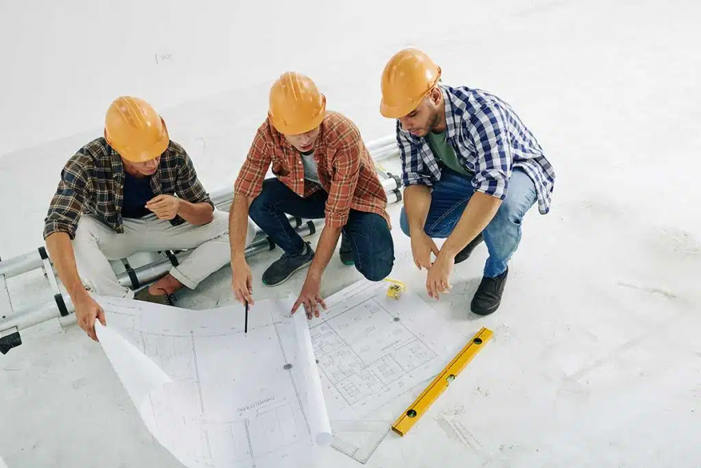 Architetti al lavoro in cantiere con una planimetria